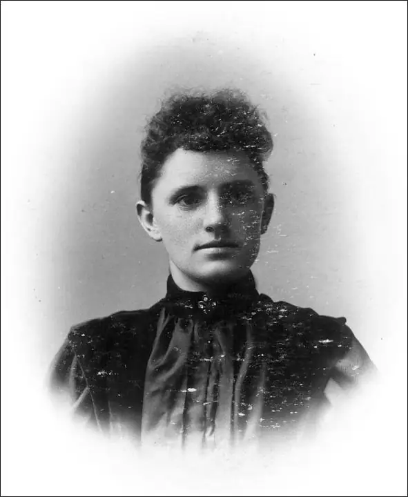 Black-and-white portrait of a young person in a high-collared dark garment.