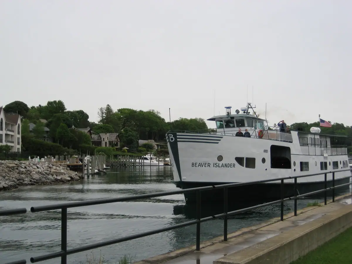 Passenger ferry docked beside a concrete pier with people on deck.