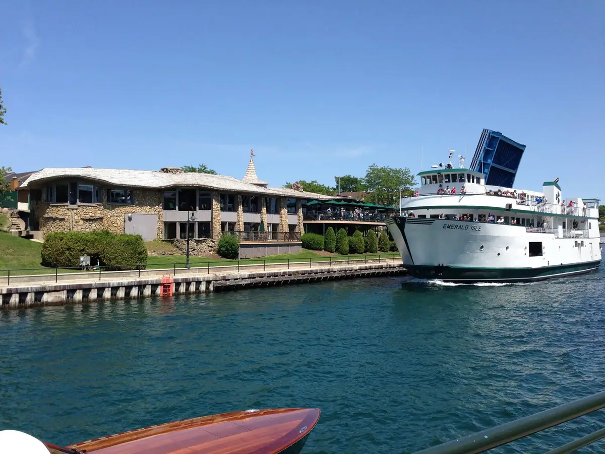 Passenger ferry EMERALD ISLE alongside a dock beside a stone waterfront building.