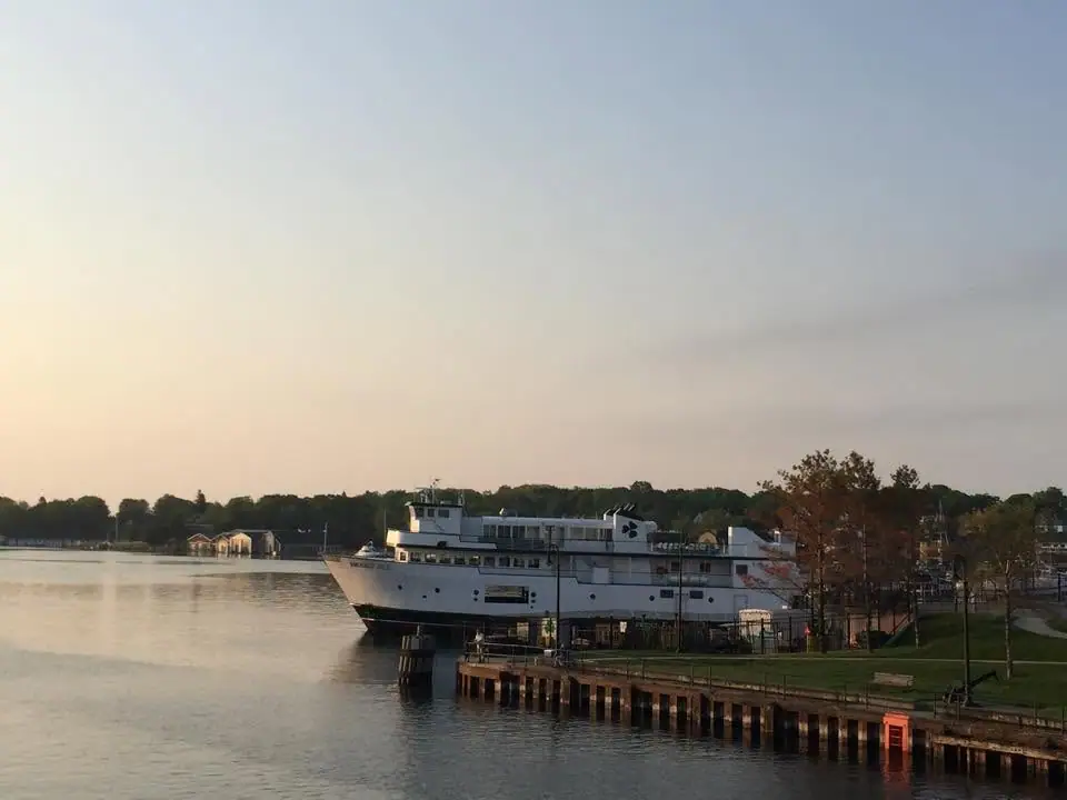White passenger ferry moored beside a pier in warm evening light.