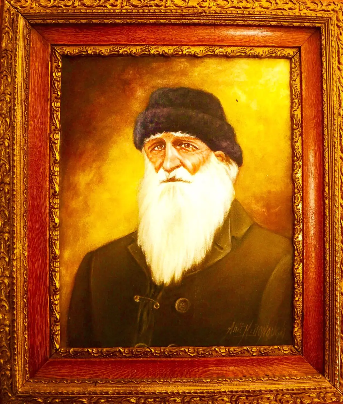 Framed portrait painting of a bearded man wearing a dark hat and jacket.