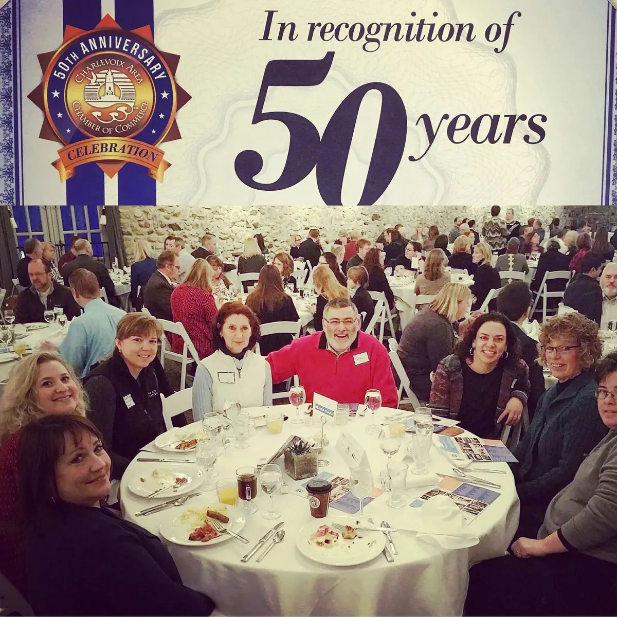 A banquet crowd sits beneath a large 50-year anniversary graphic and chamber celebration emblem.