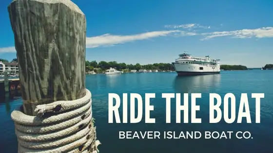 A white passenger ferry crosses blue water beside a rope-wrapped wooden piling, with large promotional lettering.