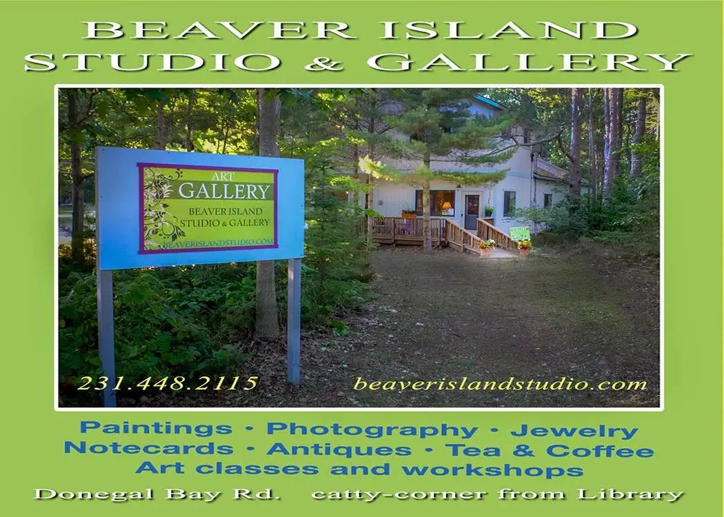 Promotional image showing a blue gallery sign beside a wooded building with a porch and ramp.