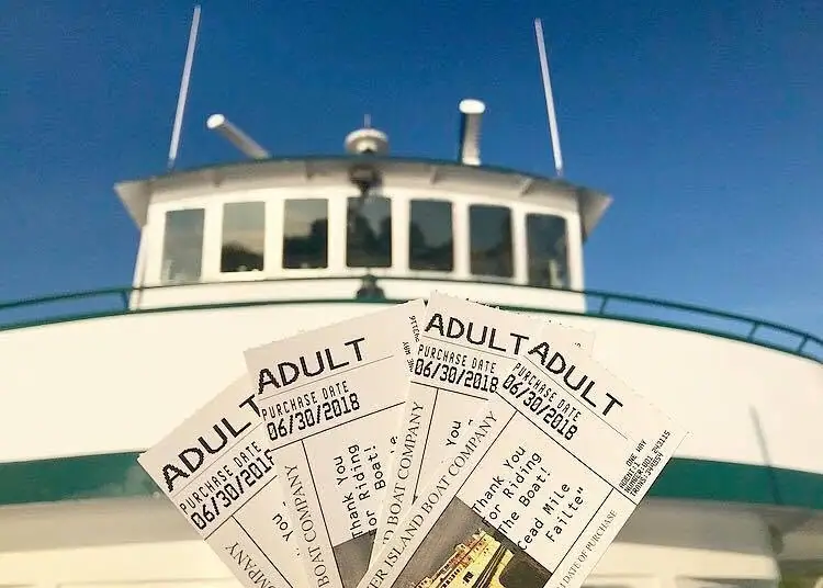 Three adult boat tickets are held in front of a vessel’s bridge and railings.