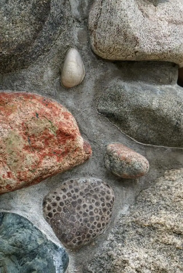 Close-up of varied stones, including a rounded stone with a distinct honeycomb pattern.