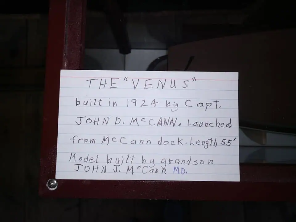 A handwritten card about “The Venus” is mounted on a dark wooden display frame.