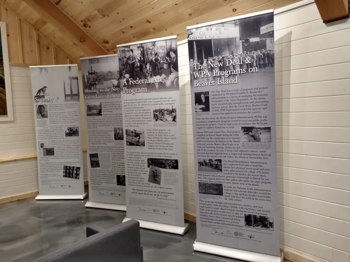 Photograph of freestanding historical exhibit banners arranged inside a wood-paneled room.