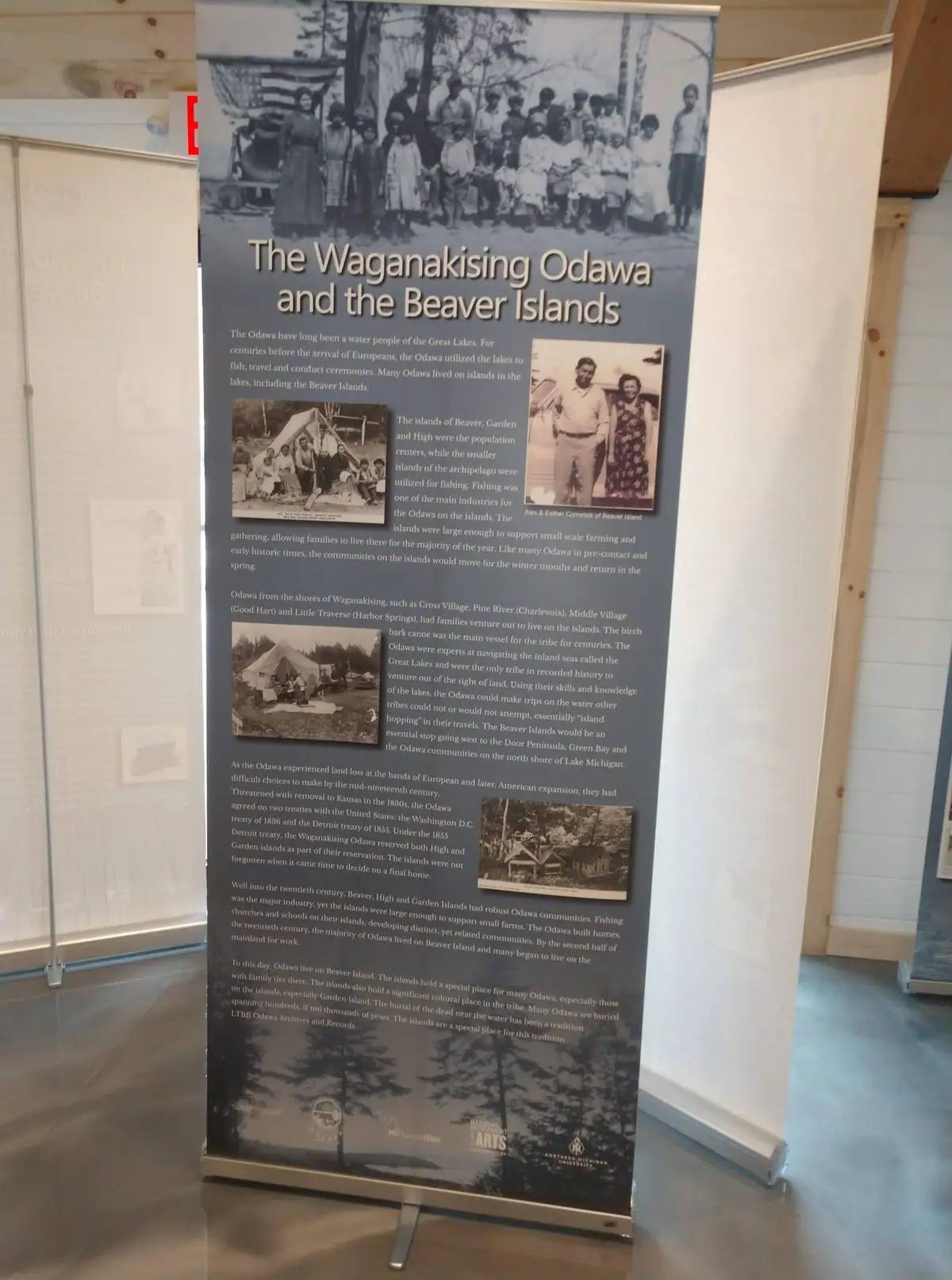 A freestanding exhibit banner displays historical photographs and text about the Odawa.