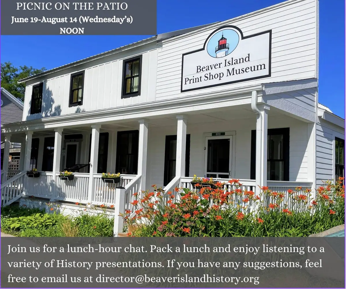 White two-story museum building with a porch, lighthouse sign, flower garden, and event text overlay.