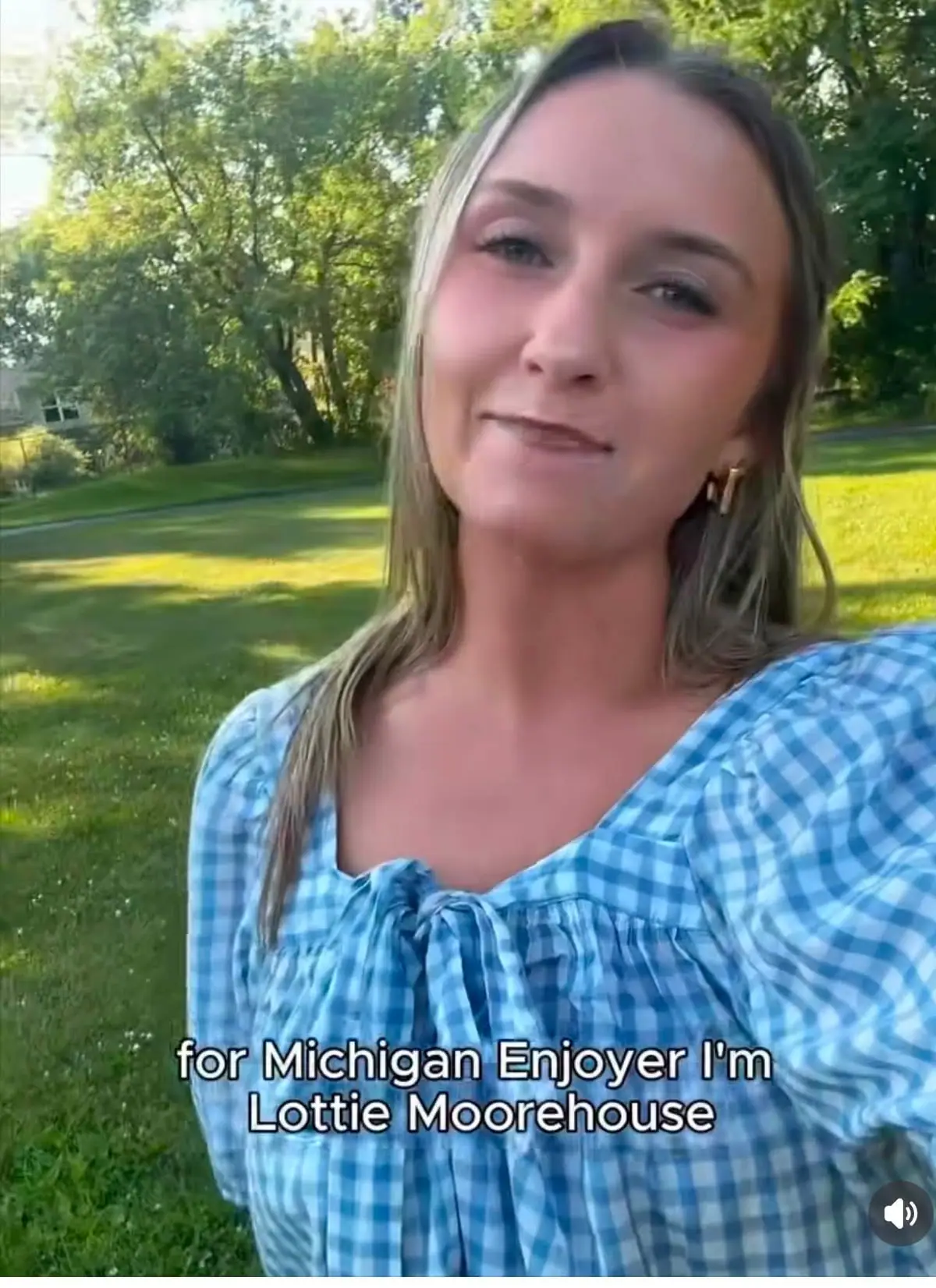 Close-up portrait of a woman in a blue gingham blouse outdoors, with overlaid caption text.