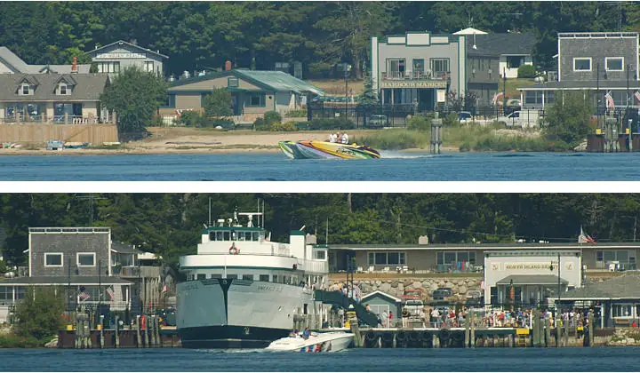 A speedboat passes a waterfront, while a ferry is docked beside a crowded pier.