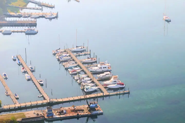 Aerial view of a marina with wooden docks and numerous moored boats.