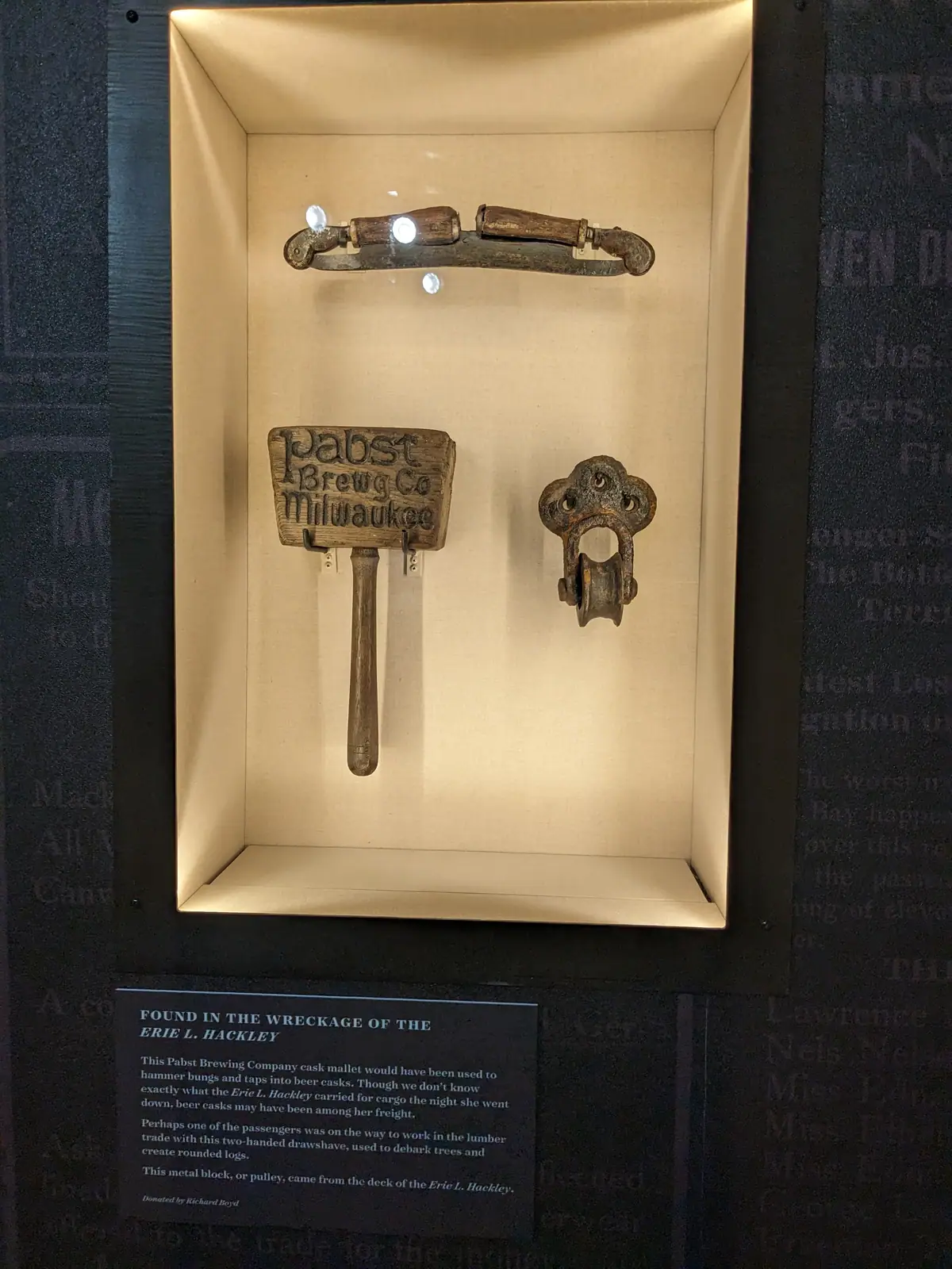A museum display case holding three objects recovered from the wreck of