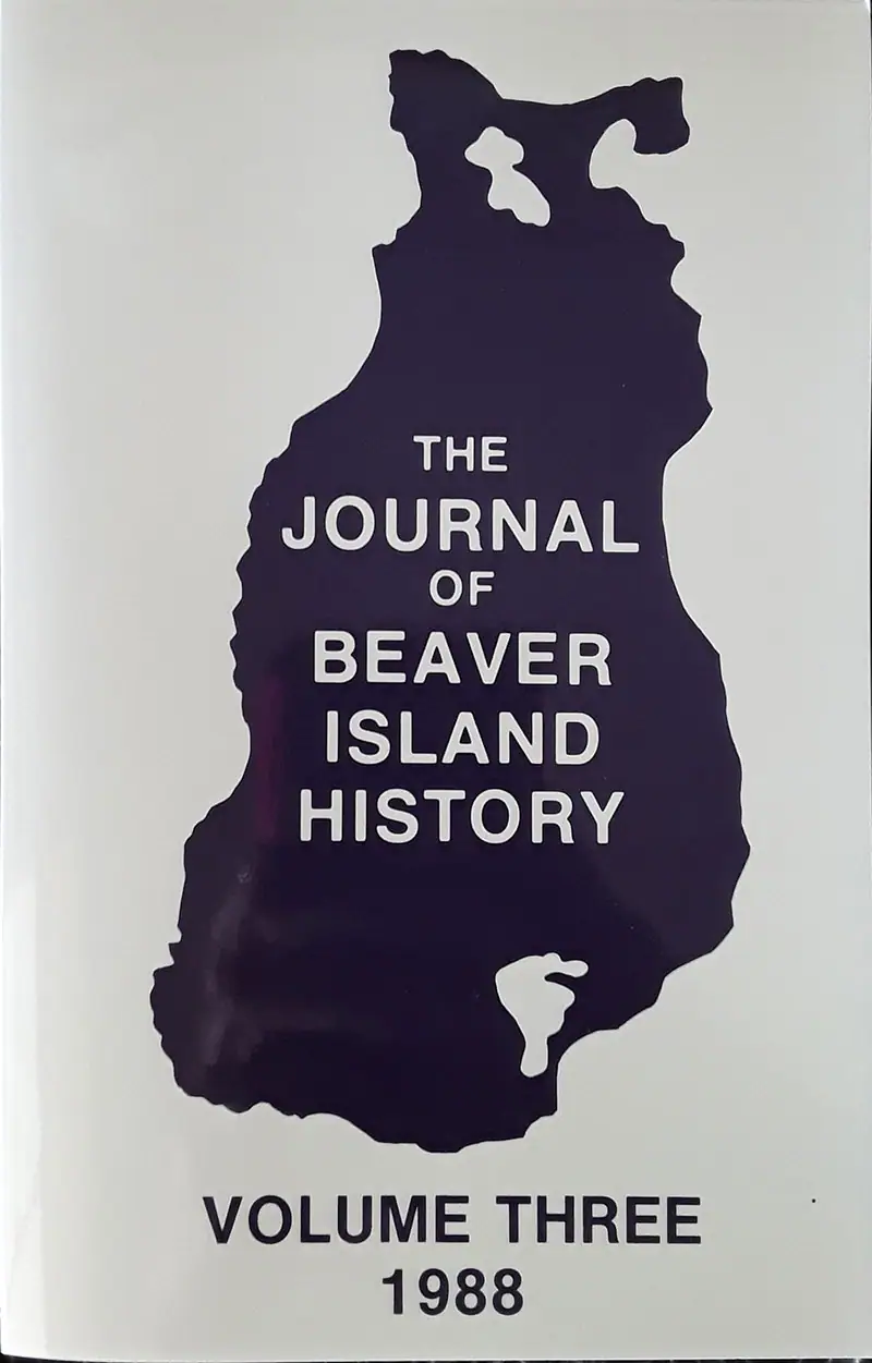 Photograph of a journal cover with a dark island-shaped silhouette and the title The Journal of Beaver Island History.