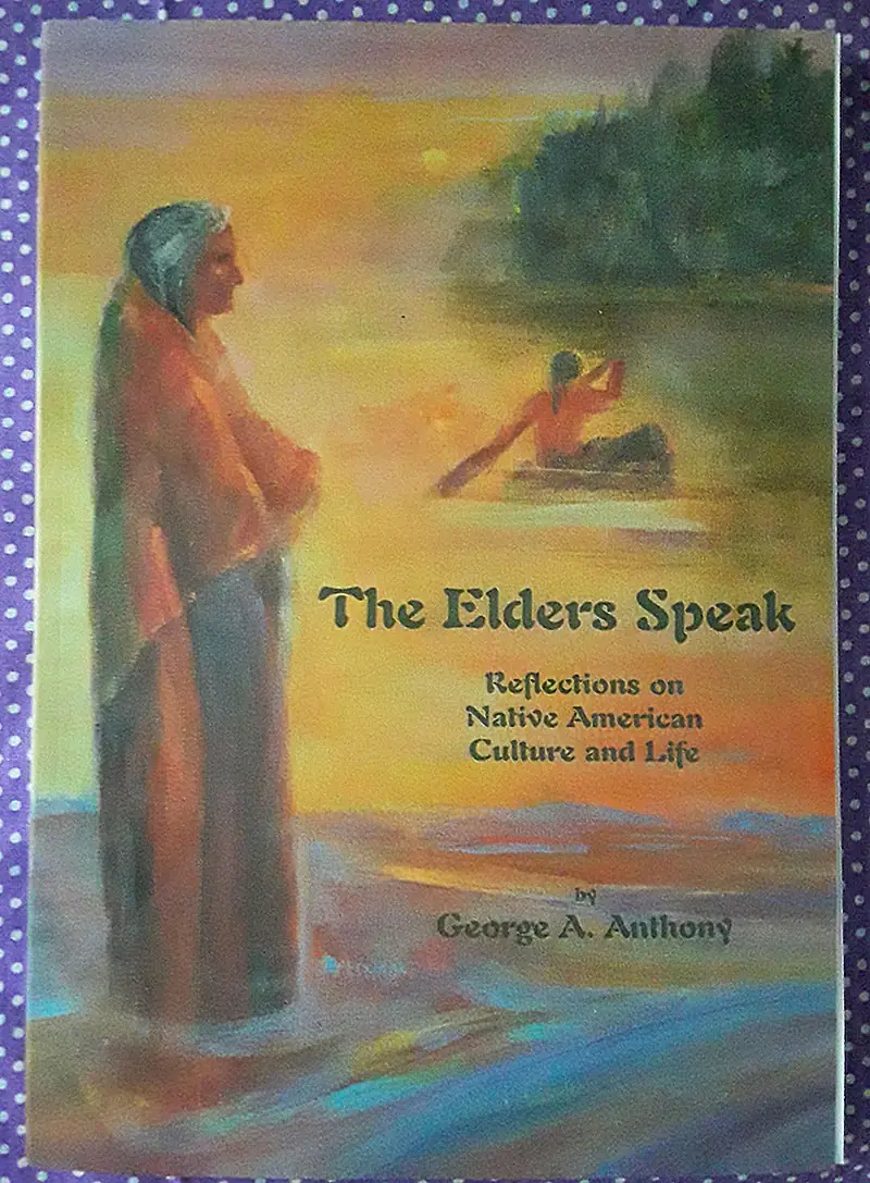 Photograph of a painted book cover showing a standing figure, a canoeist, and a glowing waterside scene.