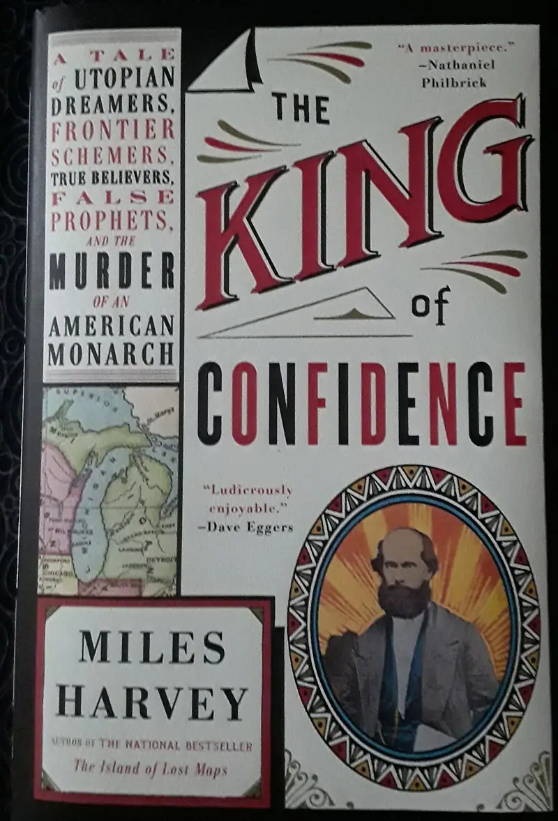 Photograph of a book cover featuring a large title, a map, and an illustrated bearded portrait.